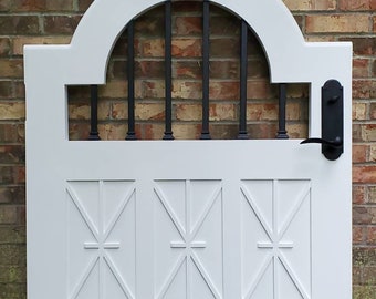 Puede incluir: Puerta de madera blanca con un arco superior de metal negro y una manija de metal negro. La puerta tiene un diseño decorativo de cuadrados superpuestos.