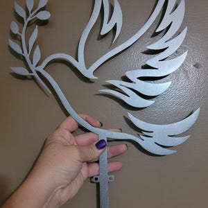 Add a touch of timeless symbolism to your holiday decor with this silver dove tree topper—its graceful silhouette and key motif evoke peace, protection, and new beginnings. Designed for versatility, it transitions beautifully from festive centerpiece to year-round wall art, making it a meaningful gift or heirloom accent.