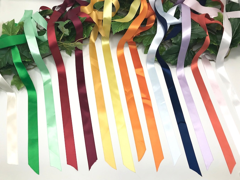 May include: Assortment of 15 satin ribbon spools in various colors, including white, green, light green, red, burgundy, yellow, orange, and lavender.