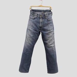 May include: Faded blue denim jeans hanging on a wooden hanger. The jeans have a classic five-pocket design, a button and zipper closure, and show signs of wear. The jeans are approximately 32 inches in length.
