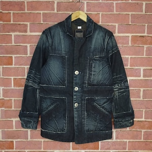 May include: A dark blue denim jacket with multiple pockets and a distressed look. The jacket has a button closure and a label that reads "MARITHE + FRANCOIS GIRBAUD".