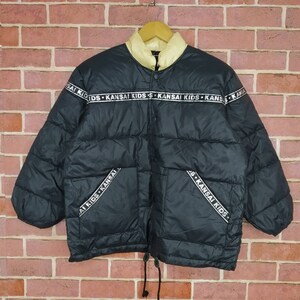 May include: Black puffer jacket with a white zipper and a white band around the collar. The band has the text "KANSAI KIDS" repeated on it.