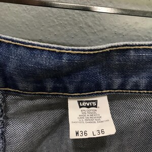 May include: Blue denim jeans featuring a white interior tag with the Levi's logo, fabric composition of 67% cotton and 33% tencel, origin marked as Mexico, and size specifications W36 L36. The garment includes U.S. patent numbers D437102S, D440028, D436714S.