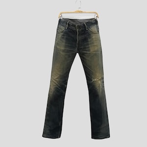 May include: Faded blue jeans with a distressed look, hanging on a wooden hanger. The jeans have a worn appearance with lighter patches and a small tear on the knee. The denim pants are a classic style.