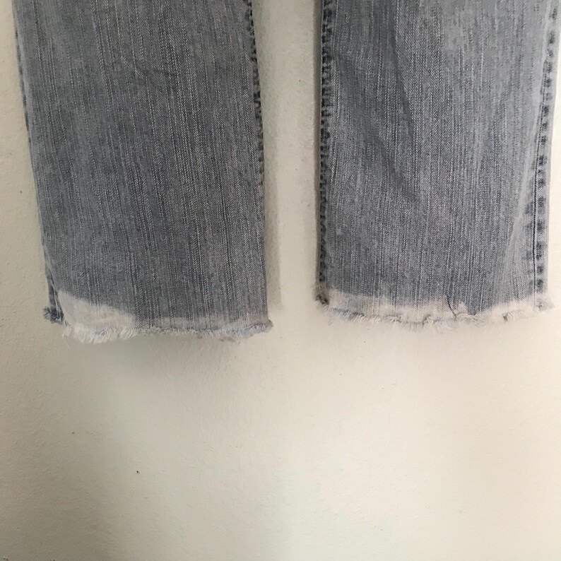 K&ouml;nnte beinhalten: Hellblaue Jeans mit ausgefransten S&auml;umen. Die Jeans haben ein klassisches F&uuml;nf-Taschen-Design und einen geraden Beinabschluss. Der Denim hat eine verwaschene Waschung f&uuml;r einen Used-Look.