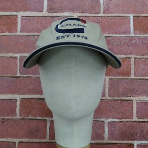 May include: A beige baseball cap with a navy blue and red logo that says "Chaps Est. 1978".