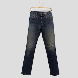 May include: Dark wash denim jeans hanging on a wooden hanger. The jeans have a classic five-pocket design, a button and zip closure, and a faded, worn appearance. The jeans are straight-legged.