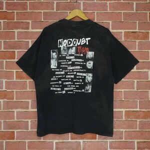 May include: Black t-shirt with a white graphic of the band No Doubt's 2002 tour dates and band member photos. The text "No Doubt Tour 2002" is printed in red.