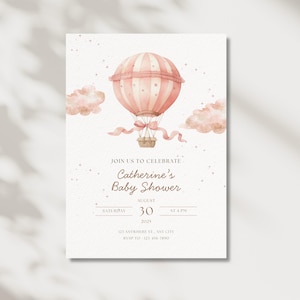 May include: A baby shower invitation featuring a watercolor illustration of a pink hot air balloon with a basket, ribbons, and clouds. The invitation includes the text "Join us to celebrate Catherine's Baby Shower" and event details.