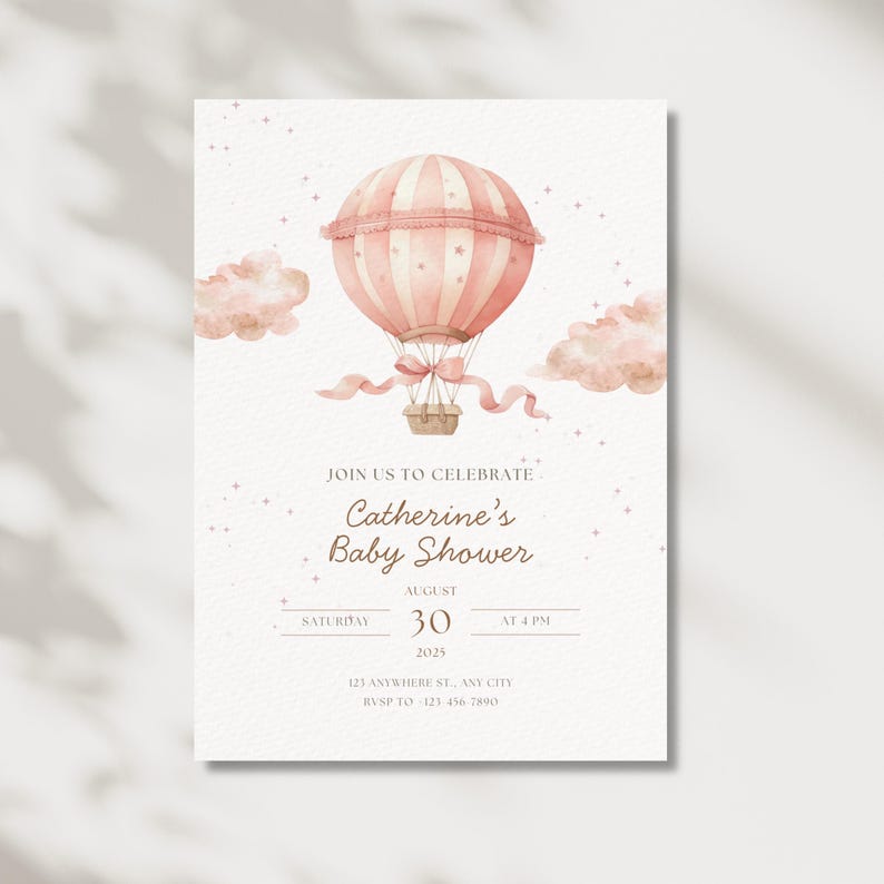May include: A baby shower invitation featuring a watercolor illustration of a pink hot air balloon with a basket, ribbons, and clouds. The invitation includes the text "Join us to celebrate Catherine's Baby Shower" and event details.