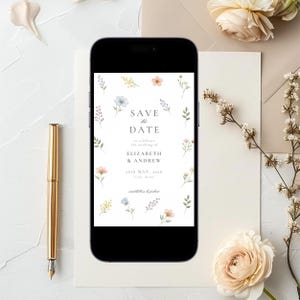 May include: A smartphone displaying a digital Save the Date card with watercolor floral illustrations. The text reads Save the Date to celebrate the wedding of Elizabeth & Andrew 26th May, 2026. The design features small blue, pink, and yellow flowers.