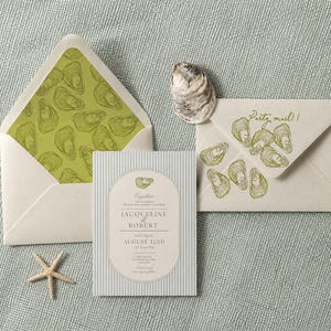 May include: A wedding invitation suite featuring a striped card with the text Jacqueline & Robert August 22nd, an envelope with a green oyster shell pattern liner, a closed envelope with oyster illustrations and the text Party mail!, and a starfish.