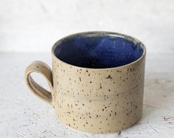 Taza de cerámica hecha a mano: arcilla moteada con interior azul mate