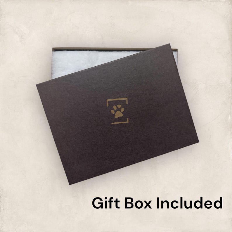 May include: A dark brown gift box with a paw print logo and the text "Gift Box Included". The box is partially open, revealing white padding inside. The box is on a light beige background.