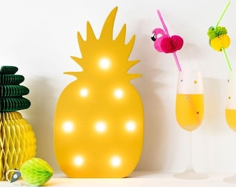 Led lamp in the shape of a yellow pineapple. Spreading a beautiful and relaxed light, designing a tropical dessert table or designing.