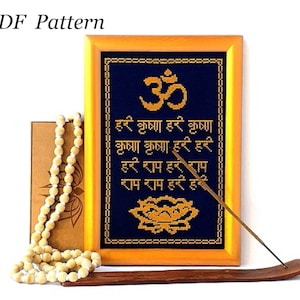 May include: A framed cross-stitch pattern with a blue background and gold embroidery. The pattern features the Sanskrit word "Om" and a mantra in Hindi. The frame is made of wood and has a gold finish. The pattern is accompanied by a wooden incense holder and a string of wooden beads.