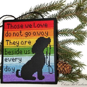 K&ouml;nnte beinhalten: Ein Regenbogenfarbener Kreuzstich-Anh&auml;nger mit einer schwarzen Silhouette eines Hundes und dem Text "Those we Love do not go away They are beside us every day".