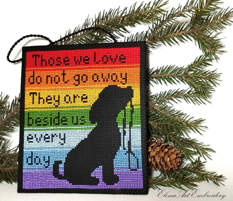 K&ouml;nnte beinhalten: Ein Regenbogenfarbener Kreuzstich-Anh&auml;nger mit einer schwarzen Silhouette eines Hundes und dem Text "Those we Love do not go away They are beside us every day".