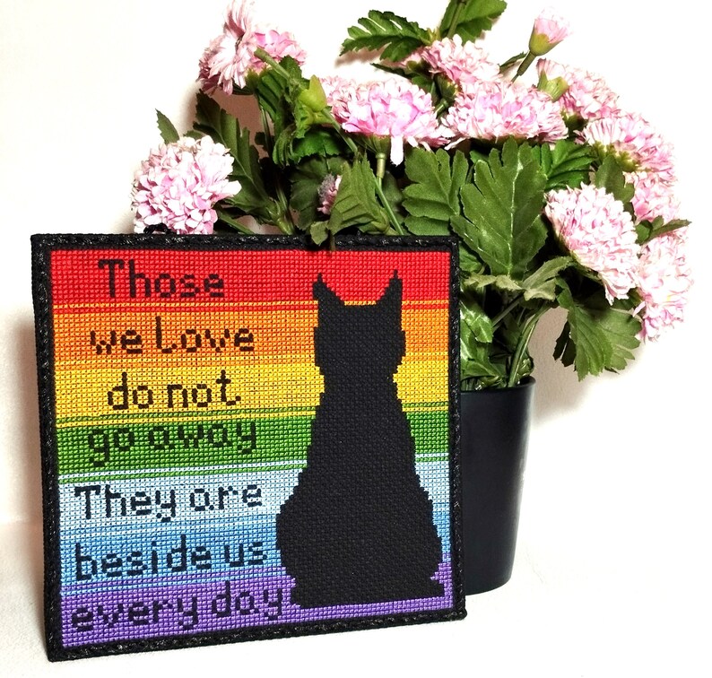 K&ouml;nnte beinhalten: Ein Regenbogen-Kreuzstich mit einer schwarzen Katzensilhouette und dem Text "Those we love do not go away. They are beside us every day."