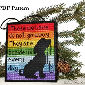 K&ouml;nnte beinhalten: Ein Kreuzstichmuster f&uuml;r einen regenbogenfarbenen Anh&auml;nger mit einer schwarzen Silhouette eines Hundes und dem Text "Those we love do not go away They are beside us every day".