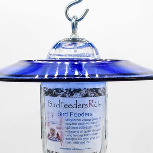 Close-up of royal blue glass bird feeder top showing hanging hook and attachment hardware
