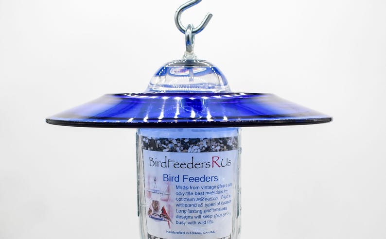 Close-up of royal blue glass bird feeder top showing hanging hook and attachment hardware