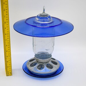 Full view of royal blue glass Mason jar bird feeder beside ruler showing overall height