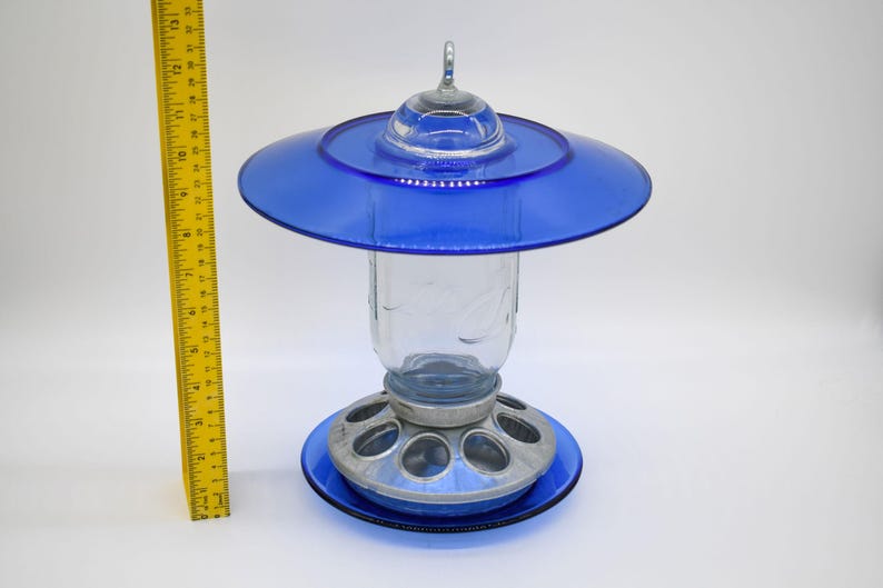 Full view of royal blue glass Mason jar bird feeder beside ruler showing overall height