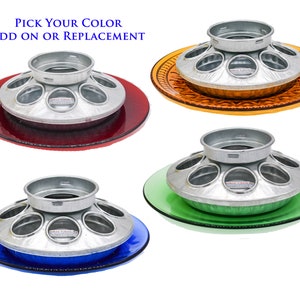 May include: A set of four bird feeders with different colored bases. The feeders are made of metal and have a circular design with multiple compartments. The bases are red, orange, green, and blue.