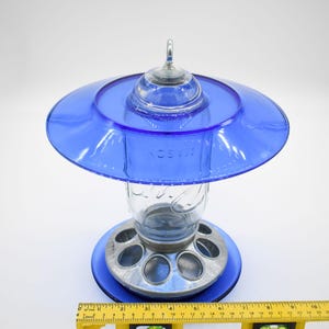 Royal blue glass hanging bird feeder with ruler showing width and overall dimensions