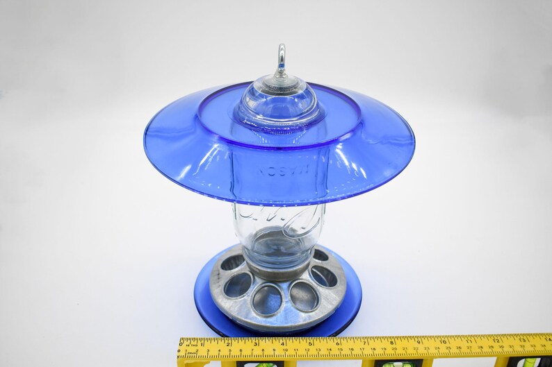 Royal blue glass hanging bird feeder with ruler showing width and overall dimensions