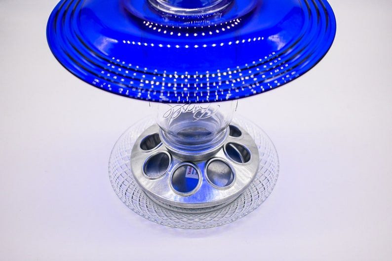 May include: A blue glass bird feeder with a clear glass jar and a metal base with six feeding ports.