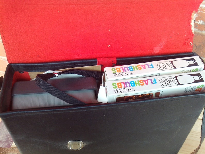 May include: A black leather case with a silver latch, containing two boxes of Sylvania M3 Blue Dot Flashbulbs.