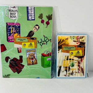 May include: Green and white wrapping paper featuring characters and scenes from the TV show "The Office". The paper includes the text "Dunder Mifflin" and "World's Best Boss".