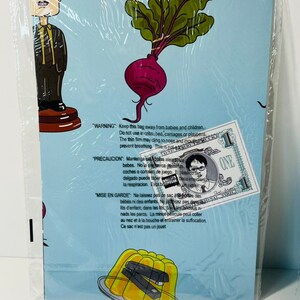 May include: A blue and white card with a cartoon image of a beet and a man with glasses. The card has a warning about keeping the bag away from babies and children. The text on the card is in English, Spanish, and French.
