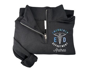 May include: Black zippered sweatshirt with a white graphic of a medical caduceus symbol with the text "Emergency Department" and the name "Andrea" underneath.
