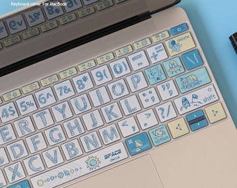 May include: A keyboard cover for a MacBook with a space-themed design. The keys are white with blue lettering and feature illustrations of planets, stars, rockets, and astronauts. The cover also includes a space-themed design on the space bar.