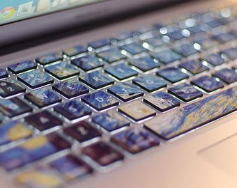 May include: A close-up of a laptop keyboard with a blue and yellow abstract art design keyboard sticker. The sticker is made to fit the keys of a Macbook keyboard. The text "KEYBOARD STICKERS" is visible at the bottom of the image.