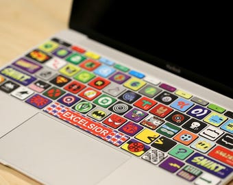 May include: A set of colorful keyboard stickers featuring various superhero logos, including Superman, Batman, Spiderman, and the Hulk. The stickers are designed to fit standard laptop keyboards and feature the text "EXCELSIOR" on the space bar.
