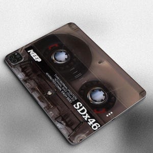 May include: A brown and black cassette tape iPad skin with the text "SDx46" and "KEEP" printed on it. The skin is designed to look like a vintage cassette tape.