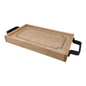 May include: A rectangular wooden serving tray with a light wood grain pattern. The tray has a dark green border and black handles on each end. The tray is designed for serving food and drinks.