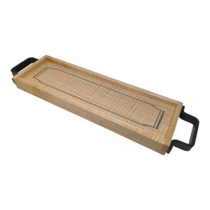 May include: A rectangular wooden serving tray with a light wood grain pattern. The tray has a dark border and black handles on each end. The center of the tray has a decorative inlay with a teal-coloured design.