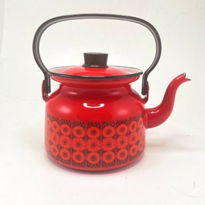 Puede incluir: Tetera de esmalte rojo con asa negra y un patrón geométrico negro y rojo.