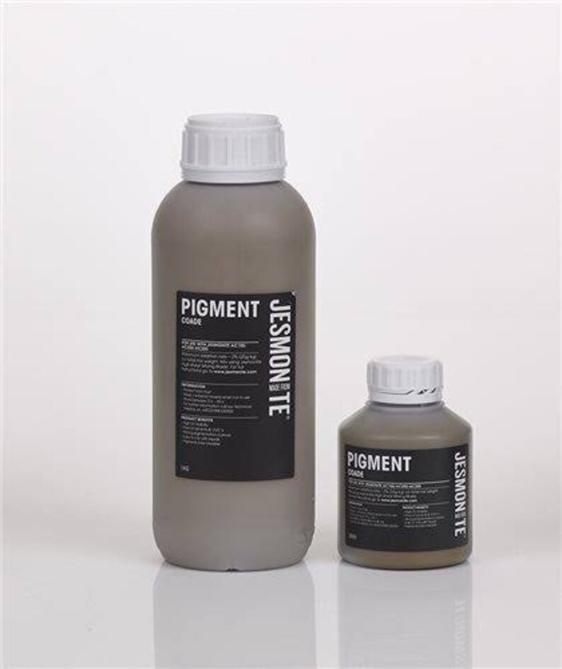 K&ouml;nnte beinhalten: Zwei Pigmentflaschen, eine gro&szlig;e und eine kleine, beide in grauer Farbe mit einem schwarzen Etikett, auf dem "Pigment Jessmonte" steht.