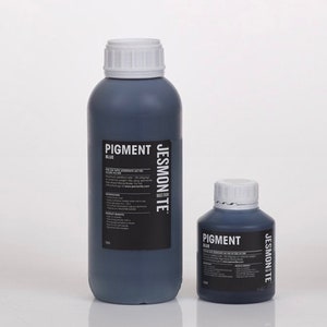 K&ouml;nnte beinhalten: Zwei Flaschen mit blauem Pigment, eine gro&szlig;e und eine kleine, beide mit der Aufschrift "Pigment Blau" und dem Markennamen "Jesmonite" auf der Seite. Die Flaschen sind aus dunkelblauem Glas und haben wei&szlig;e Deckel.