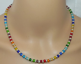 May include: A rainbow colored beaded necklace with silver beads interspersed throughout. The necklace is made of glass beads and is approximately 18 inches long.