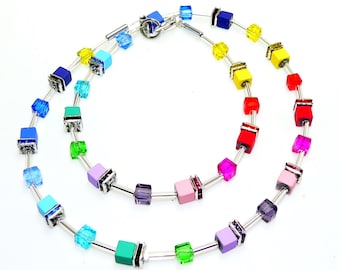 May include: A rainbow colored necklace with square beads and silver accents. The necklace is made of glass and metal.