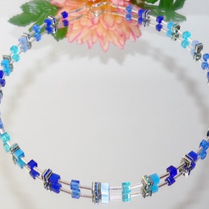 May include: A silver necklace with blue and turquoise glass beads in a graduated ombre pattern.