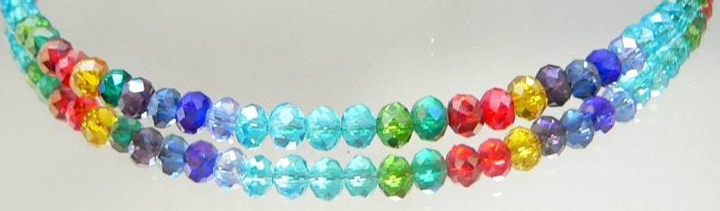 May include: Two strands of colorful, faceted beads in a rainbow of colors. The beads transition from red to orange, yellow, green, blue, and purple. The beads are strung together, creating a vibrant and eye-catching accessory.