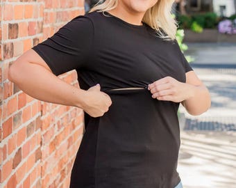 May include: A solid black short-sleeved t-shirt featuring a horizontal zipper detail across the chest area, designed with a crew neckline and a straight hemline, paired with light blue denim shorts that have a distressed, frayed hem finish.